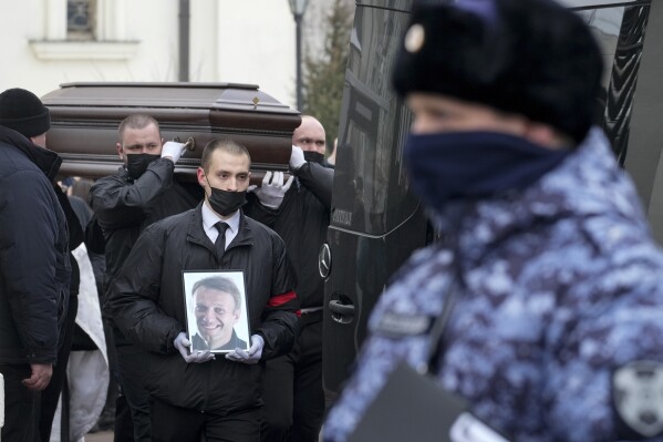 FILE - Workers carry the coffin of Russian opposition leader Alexei Navalny in Moscow, Russia, Friday, March 1, 2024. Kremlin critics say that Russia's security services focused on cracking down on opposition groups, distracting resources from monitoring terrorist threats. (AP Photo, File)