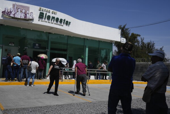 People line up outside a branch of "Banco Bienestar," or Welfare Bank, in Irapuato, Mexico, Thursday, Feb. 29, 2024. The bank was created by Mexican President Andres Manuel Lopez Obrador as a vehicle to get payments from his administration’s programs directly into the hands of Mexicans. (AP Photo/Fernando Llano)