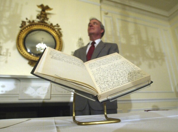 FILE - Archivist of the U.S., John Carlin, stands behind a 1947 Harry Truman presidential diary, July 10, 2003, at the National Archives in Washington. (AP Photo/Rick Bowmer, File)