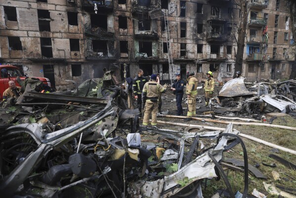 Emergency workers inspect a damaged multi-storey apartment building caused by the latest rocket Russian attack in Kryvyi Rih, Ukraine, Tuesday, June 13, 2023. (AP Photo/Andriy Dubchak)