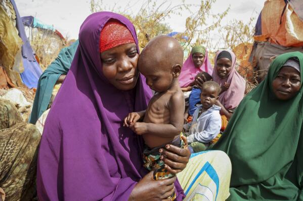 FILE - Nunay Mohamed, 25, who fled the drought-stricken Lower Shabelle area, holds her one-year old malnourished child at a makeshift camp for the displaced on the outskirts of Mogadishu, Somalia on June 30, 2022. Two U.N. agencies are warning of rising food emergencies including starvation in Sudan due to the outbreak of war and in Haiti, Burkina Faso and Mali due to restricted movements of people and goods. The four countries join Afghanistan, Nigeria, Somalia, South Sudan and Yemen at the highest alert levels. (AP Photo/Farah Abdi Warsameh, File)
