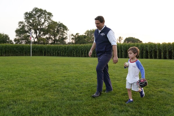 Republican presidential candidate Florida Gov. Ron DeSantis walks in the outfield with his son Mason during a campaign stop at the Field of Dreams movie site, Thursday, Aug. 24, 2023, in Dyersville, Iowa. (AP Photo/Charlie Neibergall)