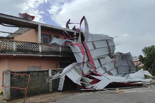 People work on a damaged building, in Mananjary district, Madagascar, Wednesday Feb. 22, 2023 after cyclone Freddy reached Madagascar. A slightly weakened Cyclone Freddy has made landfall in Madagascar, where schools, businesses and public transportation were shut down ahead of its arrival. Freddy was packing winds gusting to 180 kilometers per hour, or about 111 miles per hour, as it came ashore in a nation already hit in January by a tropical storm that killed at least 30 people. (AP Photo/Solofo Rasolofomanana)