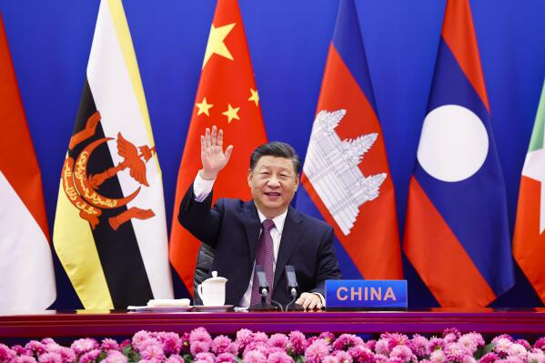 In this photo released by Xinhua News Agency, Chinese President Xi Jinping waves as he chairs the ASEAN-China Special Summit to commemorate the 30th Anniversary of ASEAN-China Dialogue Relations via video link from Beijing, China on Monday, Nov. 22, 2021. Xi on Monday said his country will not seek dominance over Southeast Asia or bully its smaller neighbors, amid ongoing friction over the South China Sea. (Huang Jingwen/Xinhua via AP)
