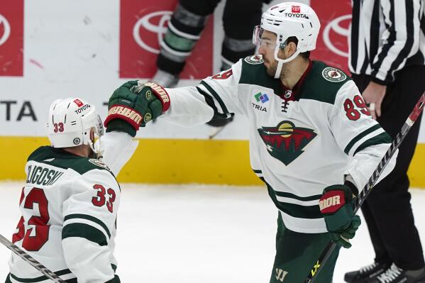 Minnesota Wild center Frederick Gaudreau (89) is congratulated by teammate Alex Goligoski (33) after Gaudreau scores a shoot-out in an NHL hockey game against the Dallas Stars in Dallas, Sunday, Dec. 4, 2022. The Wild won 6-5. (AP Photo/LM Otero)