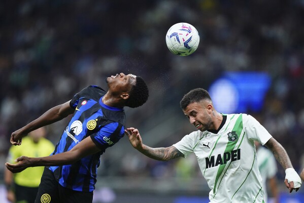 Denzel Dumfries, del Inter, y Matheus Henrique, del Sassuolo, disputan un centro en un partido de la Serie A italiana, el miércoles 27 de septiembre de 2023 (Spada/LaPresse via AP)
