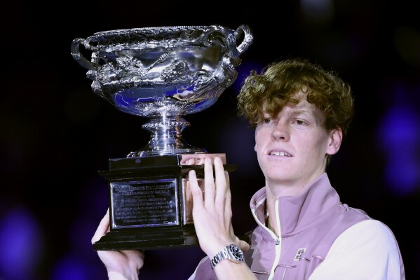 FILE - Jannik Sinner of Italy holds the Norman Brookes Challenge Cup aloft after defeating Daniil Medvedev of Russia in the men's singles final at the Australian Open tennis championships at Melbourne Park, in Melbourne, Australia, Sunday, Jan. 28, 2024. Sinner made his debut at No. 1 in the ATP rankings on Monday, June 10, moving up one spot to replace the injured Novak Djokovic. (AP Photo/Asanka Brendon Ratnayake, File)