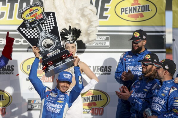 Kyle Larson (izquierda adelante) levanta el trofeo luego de ganar la carrera del Nascar Cup Series en el Las Vegas Motor Speedway, el domingo 3 de marzo de 2024, en Las Vegas. (AP Foto/Ian Maule)