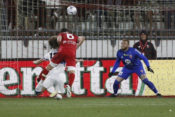 Atalanta's Charles De Ketelaere, bottom left, scores their side's first goal of the game during the Serie A soccer match between Monza and Atalanta at the U-Power Stadium in Monza, Italy, Sunday, April 21 , 2024. (Alberto Mariani/LaPresse via AP)