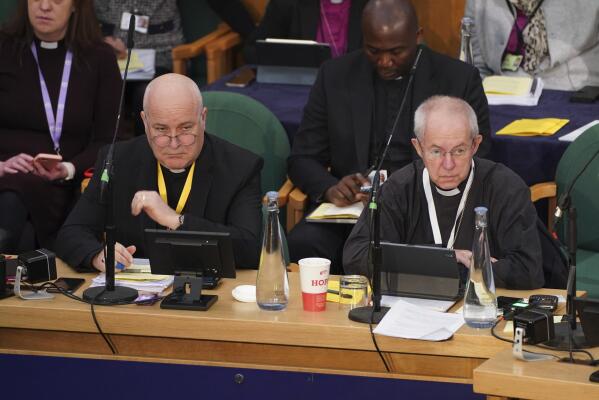 The Archbishop of York, Stephen Cottrell, left and The Archbishop of Canterbury, Justin Welby, gather at the General Synod of the Church of England, at Church House to consider a motion which reviews the church's failure "to be welcoming to LGBTQI+ people" and the harm they have faced and still experience, in London, Thursday, Feb. 9, 2023. (James Manning/PA via AP)