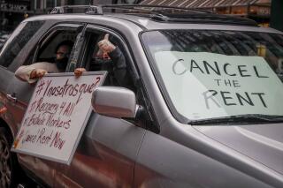 FILE - This photo from Friday May 1, 2020, shows May Day protesters with signs calling for rent cancellation, as they drive in a caravan en route to the offices of New York Gov. Andrew Cuomo in New York. Advocates hope New York's revamped rent relief program will finally help tenants and landlords who've struggled to get assistance since the start of the COVID-19 pandemic. (AP Photo/John Minchillo, File)