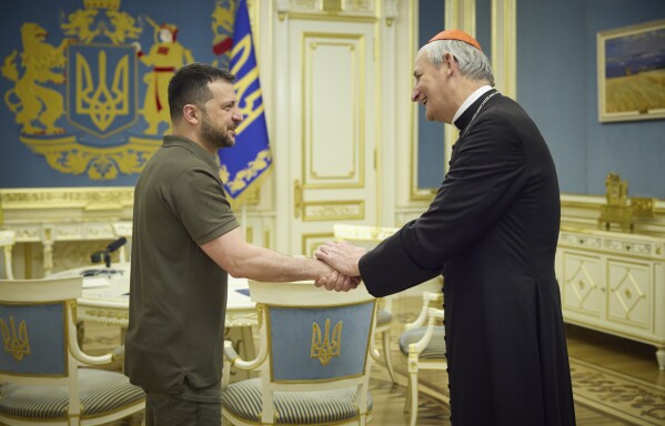 In this photo provided by the Ukrainian Presidential Press Office, Ukrainian President Volodymyr Zelenskyy, left, shakes hands with Cardinal Matteo Zuppi, head of the CEI (Italian Conference of Bishops) in Kyiv, Ukraine, Tuesday, June 6, 2023. (Ukrainian Presidential Press Office via AP)