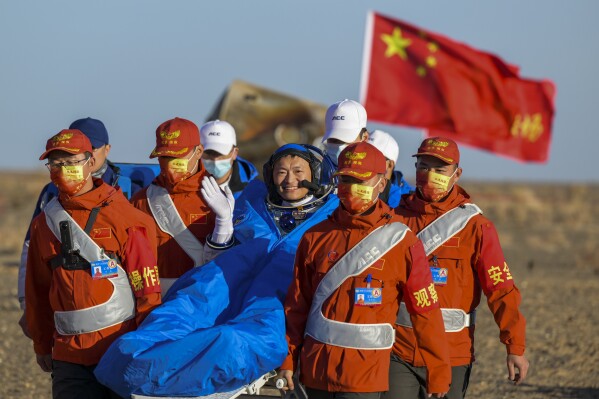 In this photo released by Xinhua News Agency, astronaut Gui Haichao waves as he is carried out of the re-entry capsule of the Shenzhou-14 manned space mission after it landed successfully at the Dongfeng landing site in northern China's Inner Mongolia Autonomous Region, Tuesday, Oct. 31, 2023. The previous crew of China's orbiting space station returned to earth Tuesday morning, all reportedly in good health, amid a sharpening rivalry with the U.S. over space exploration and plans to put astronauts on the moon before 2030. (Li Zhipeng/Xinhua via AP)