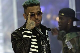 
              FILE - In this Sept.21, 2018 file photo, singer Chris Brown performs during Philipp Plein's women's 2019 Spring-Summer collection, unveiled during the Fashion Week in Milan, Italy. Two police officials say U.S. singer Chris Brown and two other people are in custody in Paris after a woman filed a rape complaint. (AP Photo/Luca Bruno, File)
            