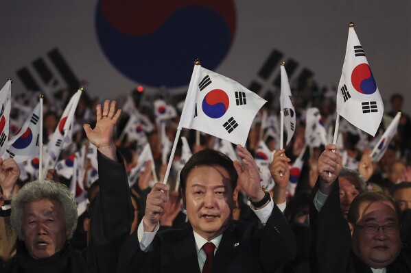 South Korea's President Yoon Suk Yeol cheers during a ceremony of the 105th anniversary of the March 1st Independence Movement Day in Seoul, South Korea, Friday, March 1, 2024. (Kim Hong-Ji/Pool Photo via AP)
