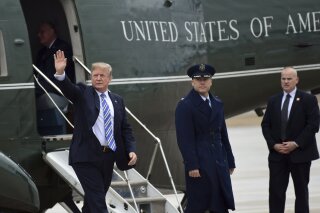 
              President Donald Trump waves as he walks off of Marine One and heads to Air Force One at Andrews Air Force Base in Md., Friday, Feb. 16, 2018. Trump is heading to Florida to spend the weekend at his Mar-a-Lago estate. (AP Photo/Susan Walsh)
            