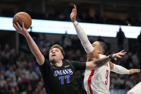 Dallas Mavericks' Luka Doncic (77) gets by Houston Rockets' Dillon Brooks (9) to take a shot in the second half of an NBA basketball game in Dallas, Tuesday, Nov. 28, 2023. (AP Photo/Tony Gutierrez)