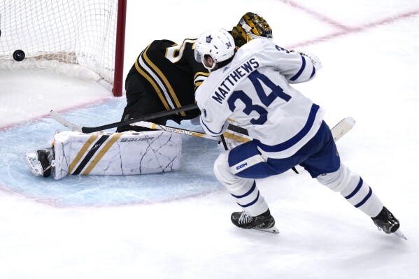 Toronto Maple Leafs center Auston Matthews (34) beats Boston Bruins goaltender Linus Ullmark, back, for a goal during the third period of Game 2 of an NHL hockey Stanley Cup first-round playoff series, Monday, April 22, 2024, in Boston. (AP Photo/Charles Krupa)