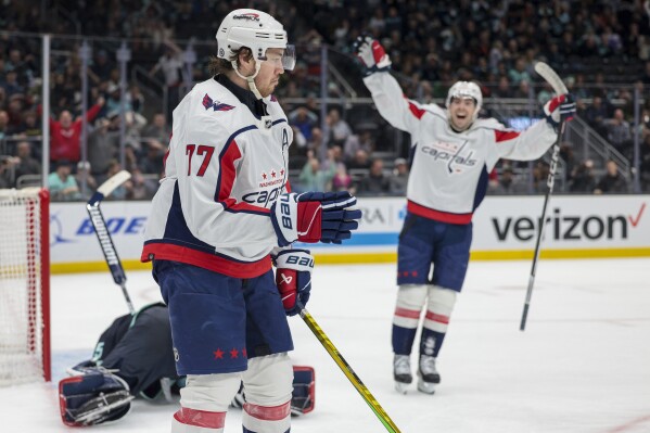 Washington Capitals right wing T.J. Oshie (77) and center Hendrix Lapierre react after Oshie's goal against Seattle Kraken goaltender Joey Daccord during the second period of an NHL hockey game Thursday, March 14, 2024, in Seattle. (AP Photo/Jason Redmond)