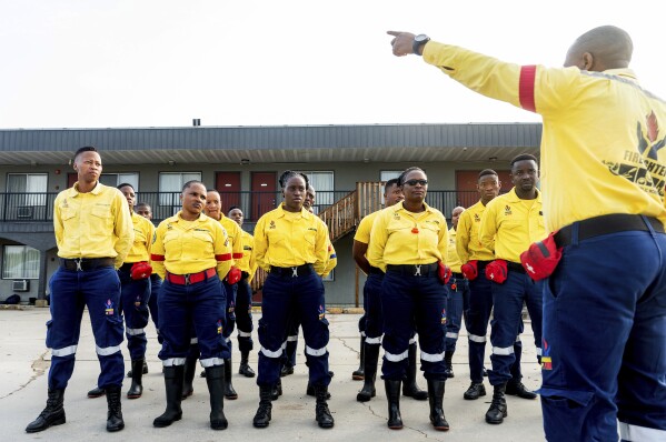 South African firefighters gather for their morning meeting in Fox Creek, Alberta, on Tuesday, July 4, 2023. Several countries, including South Africa, deployed firefighters to Canada to help local efforts to control widespread wildfires. (AP Photo/Noah Berger)