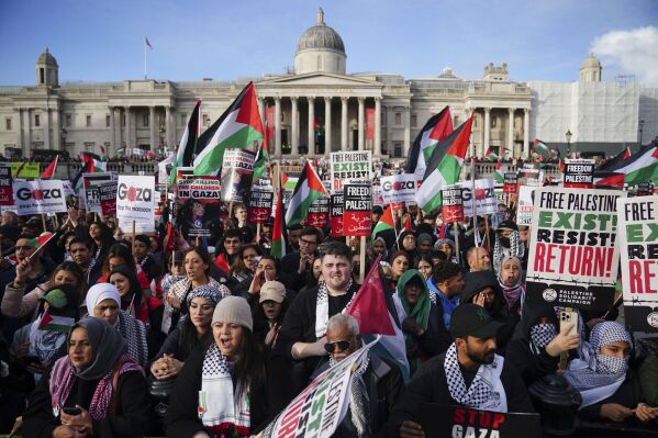 Protesters hold placards and Palestinian flags during a pro-Palestinian rally in Trafalgar Square, London, Saturday Nov. 4, 2023. (Victoria Jones/PA via AP)