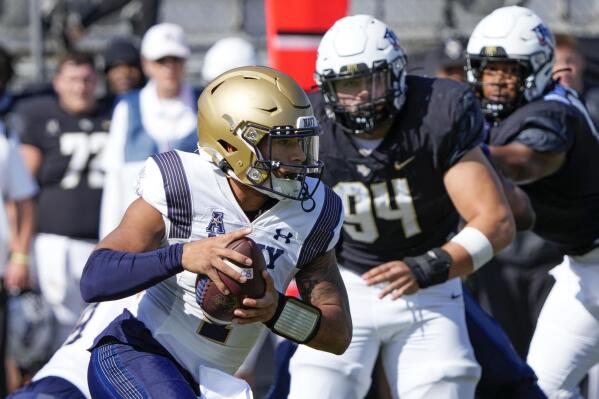Navy quarterback Xavier Arline, left, scrambles past Central Florida defensive tackle Anthony Montalvo (94) during the first half of an NCAA college football game, Saturday, Nov. 19, 2022, in Orlando, Fla. (AP Photo/John Raoux)