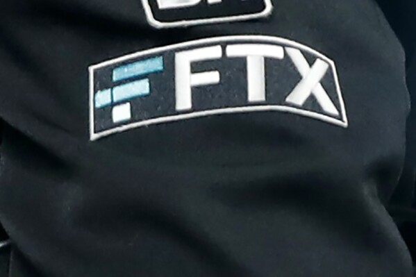 FILE - The FTX logo appears on home plate umpire Jansen Visconti's jacket at a baseball game with the Minnesota Twins on Sept. 27, 2022, in Minneapolis. Failed cryptocurrency exchange FTX says that nearly all of its customers will receive the money back that they are owed, and some will get more than that, according to its reorganization plan. FTX said in a court filing Tuesday, May 7, 2024 that it owes about $11.2 billion to its creditors. (AP Photo/Bruce Kluckhohn, File)