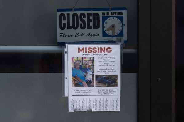FILE - A missing person flyer for Joseph "Lomsey" Lara is posted on the door of a business in a shopping mall in Lahaina, Hawaii, Monday, Aug. 21, 2023, following wildfires that devastated parts of the Hawaiian island of Maui earlier in the month. Nearly a month after the deadliest U.S. wildfire in more than a century killed scores of people, authorities on Maui are working their way through a list of the missing that has grown almost as quickly as names have been removed. (AP Photo/Jae C. Hong, File)