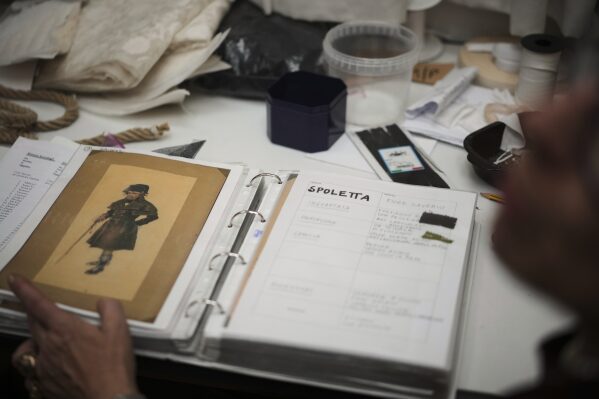 Anna Biagiotti, the costume director for the "Teatro dell' Opera" opera house shows drawings, sketches and notes for the costumes made 125 years ago for the first ever performance of Giacomo Puccini's opera "Tosca", in Rome, Thursday, April 10, 2025. (AP Photo/Andrew Medichini)