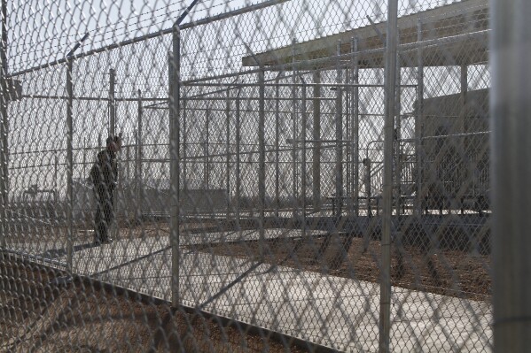 A Border Patrol agent wait to show reporters an immigration holding facility, Tuesday, Feb. 25, 2020, in El Paso, Texas. (AP Photo/Cedar Attanasio, File)