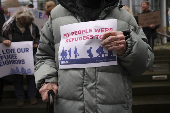 Martin Bernstein, de 95 años y cuyos padres fueron refugiados, sostiene un cartel durante un acto en el exterior de la Corte de Distrito de Estados Unidos luego de que un juez federal bloqueó una iniciativa de Donald Trump para suspender el programa de admisiones de refugiados del país, el 25 de febrero de 2025 en Seattle. (AP Foto/Ryan Sun)