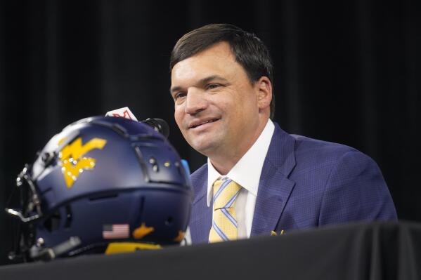 FILE  - West Virginia head football coach Neal Brown smiles as he listens to a question during NCAA college football Big 12 media days Wednesday, July 14, 2021, in Arlington, Texas. West Virginia went 6-4 a year ago and will need improvements, especially on offense, in order to challenge for a Big 12 title this season. The Mountaineers open the season Sept. 4 at Maryland. (AP Photo/LM Otero)