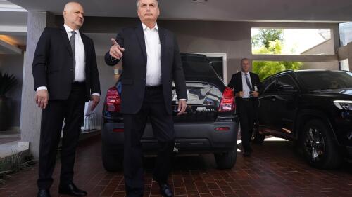 Former Brazilian President Jair Bolsonaro speaks to the press outside his house after Federal Police agents carried out a search and seizure warrant in Brasilia, Brazil, Wednesday, May 3, 2023. When asked about the search of Bolsonaro’s home in Brasilia, the Federal Police press office gave a statement saying officers were carrying out searches and arrests related to the introduction of fraudulent data related to the COVID-19 vaccine into the nation’s health system. (AP Photo/Eraldo Peres)