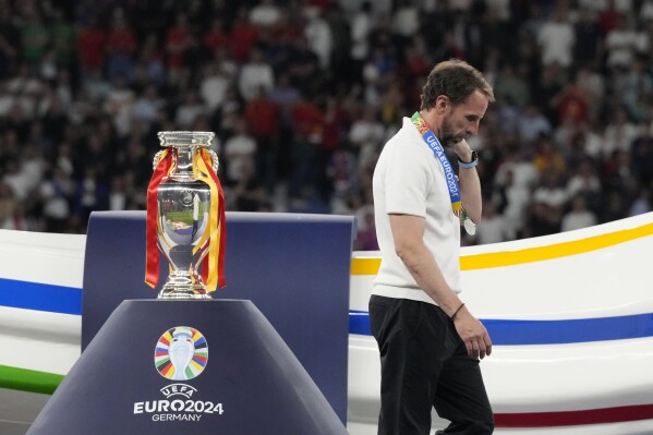 FILE - England's manager Gareth Southgate walks past the trophy at the end of the final match between Spain and England at the Euro 2024 soccer tournament in Berlin, Germany, Sunday, July 14, 2024. Spain won 2-1. Gareth Southgate announces he will step down as England manager. (AP Photo/Frank Augstein, File)