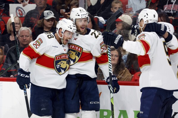 Florida Panthers' Carter Verhaeghe, center, celebrates his goal with Nate Schmidt (88) and Sam Bennett (9) during the first period of Game 2 of the NHL hockey Stanley Cup Eastern Conference finals in Raleigh, N.C., Thursday, May 22, 2025. (AP Photo/Karl DeBlaker)