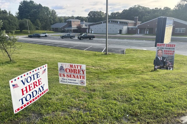 Signs for Matt Corey, a Republican candidate for U.S. Senate, stand posted outside the Sayles School in Sprague, Conn., Tuesday, Aug. 13, 2024, for a statewide primary. (AP Photo/Susan Haigh)