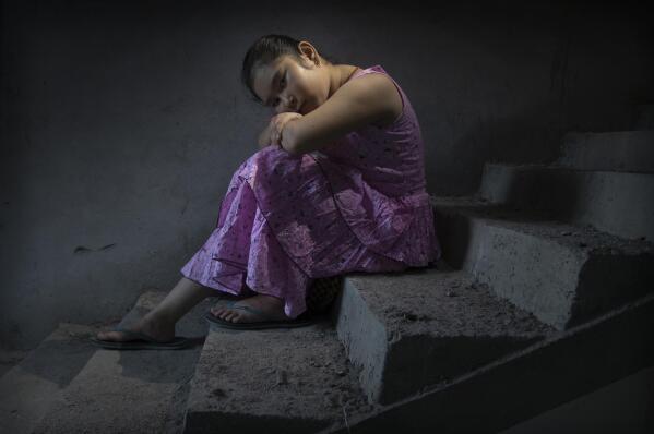 Jeshmi Narzary, 10, sits on the stairs of her aunt's house after both her parents died of COVID-19, in Kokrajhar, in the northeastern Indian state of Assam, Friday, June 25, 2021. Jeshmi was adopted by her mother's sister Phulmati Narzary Goyary. (AP Photo/Anupam Nath)