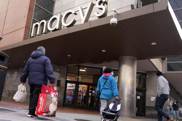 Shoppers walk to the Macy's store in the Downtown Crossing district, Wednesday, Nov. 17, 2021, in Boston.  Macy’s Inc. reported fiscal third-quarter net income of $239 million Thursday, Nov. 18, after reporting a loss in the same period a year earlier.  (AP Photo/Charles Krupa)