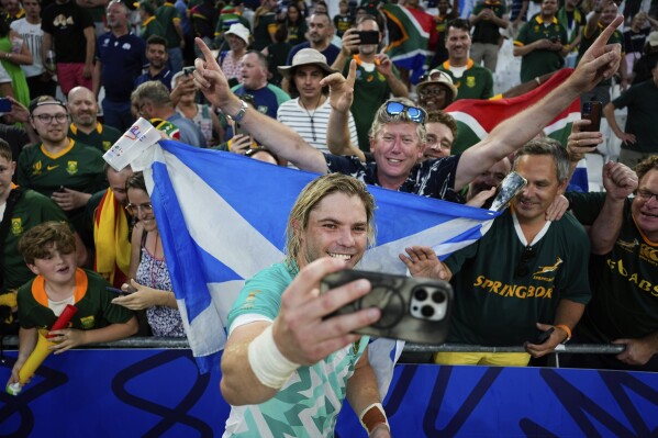 South Africa's Faf de Klerk takes a selfie with supporters as he celebrates after the Rugby World Cup Pool B match between South Africa and Scotland at the Stade de Marseille in Marseille, France, Sunday, Sept. 10, 2023. (AP Photo/Pavel Golovkin)