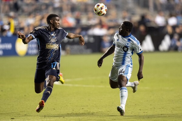 Philadelphia Union's Damion Lowe, left, and CF Montreal's Sunusi Ibrahim, right, go after the ball during the second half of an MLS soccer match, Saturday, June 1, 2024, in Chester, Pa. (AP Photo/Chris Szagola)