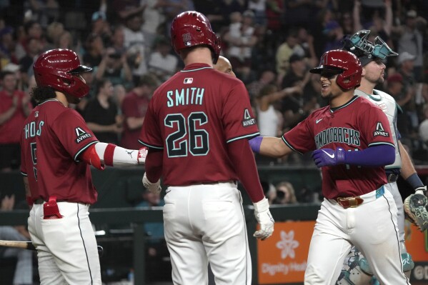 Arizona Diamondbacks' Gabriel Moreno celebrates with Alek Thomas (5) and Pavin Smith (26) after hitting a three run home run against the Seattle Mariners in the sixth inning during a baseball game, Tuesday, June 10, 2025, in Phoenix. (AP Photo/Rick Scuteri)