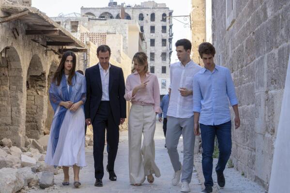 In this photo released on the official Facebook page of Syrian Presidency, Syrian President Bashar Assad, second left, and his wife Asma, center, and their children Zein, left, Karim, right, and Hafez walk outside the Great Mosque of Aleppo, also known as the Umayyad Mosque, in the Old City of Aleppo, Syria, Friday, July 8, 2022. The visit by Assad and his family to the city of Aleppo, Syria's largest and once the nation's commercial center, was his first since government forces captured its rebel-held eastern neighborhoods in December 2016 after a monthslong battle. (Syrian Presidency Facebook page via AP)