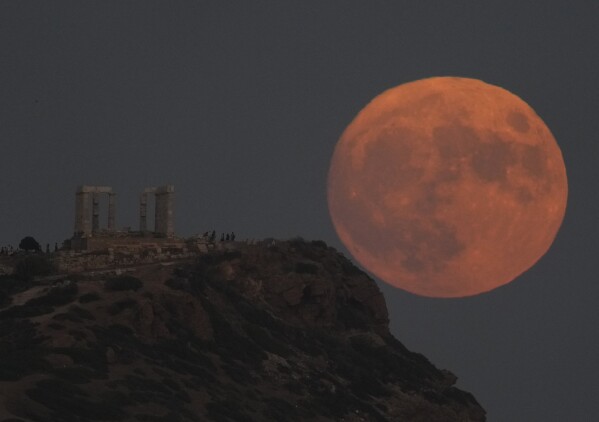 The supermoon rises behind the ancient temple of Poseidon at Cape Sounion, about 70 kilometers (45 miles) south of Athens, Greece, Wednesday, Aug. 30, 2023.  (AP Photo/Thanassis Stavrakis)