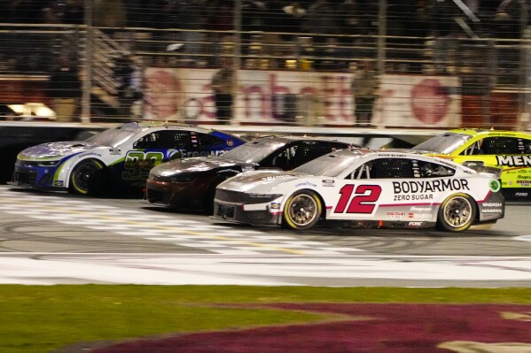 Daniel Suarez (99), left, edges out Kyle Busch (8), center, and Ryan Blaney (12) at the finish line to win during the NASCAR auto race at Atlanta Motor Speedway Sunday, Feb. 25, 2024, in Hampton, Ga. (AP Photo/John Bazemore)