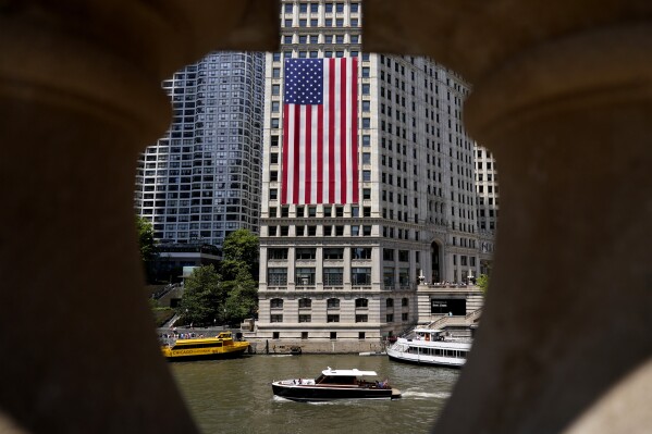 An American flag hangs from a building overlooking the Chicago River in Chicago Monday, July 3, 2023, a day after heavy rains flooded Chicago Streets and neighborhoods. (AP Photo/Nam Y. Huh)