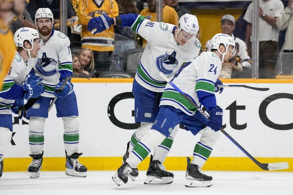 Vancouver Canucks defenseman Nikita Zadorov (91) congratulates center Pius Suter (24) after his goal against the Nashville Predators during the third period in Game 6 of an NHL hockey Stanley Cup first-round playoff series Friday, May 3, 2024, in Nashville, Tenn. The Canucks won 1-0 winning the series four games to two. (AP Photo/George Walker IV)