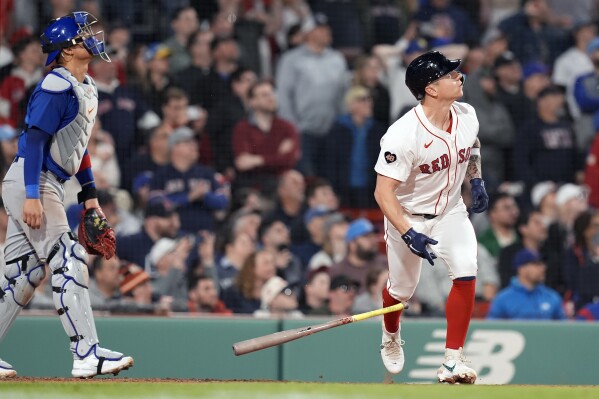 Boston Red Sox's Tyler O'Neill, right, watches his walkoff RBI single in front of Chicago Cubs catcher Miguel Amaya, left, during the ninth inning of a baseball game, Sunday, April 28, 2024, in Boston. (AP Photo/Michael Dwyer)