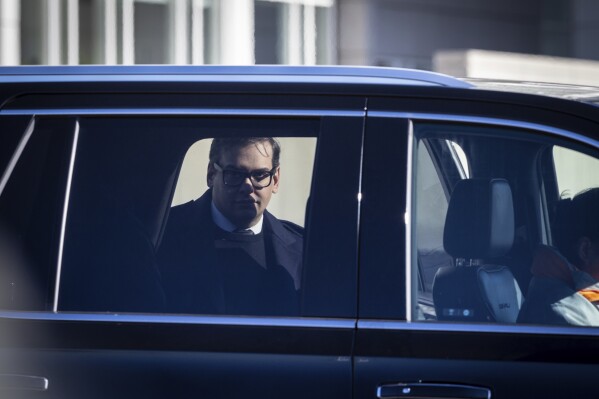 Former U.S. Rep George Santos leaves the federal courthouse with his lawyer in Central Islip, N.Y. on, Tuesday, Dec. 12, 2023, in New York. (AP Photo/Stefan Jeremiah)