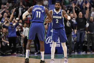 Dallas Mavericks guard Kyrie Irving (2) is congratulated by forward Tim Hardaway Jr. (11) after making a 3-point basket during the second half of the team's NBA basketball game against the Sacramento Kings in Dallas, Wednesday, April 5, 2023. (AP Photo/Sam Hodde)