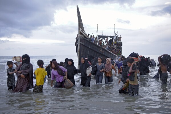 FILE - Ethnic Rohingya disembark from their boat upon landing on a beach in Ulee Madon, North Aceh, Indonesia, on Nov. 16, 2023. A dramatic story of survival and rescue off the western coast of Indonesia’s Aceh province has put the spotlight again on the plight of ethnic Rohingya Muslim refugees from Myanmar who make extremely dangerous voyages across the Indian Ocean to seek better lives. (AP Photo/Rahmat Mirza, File)